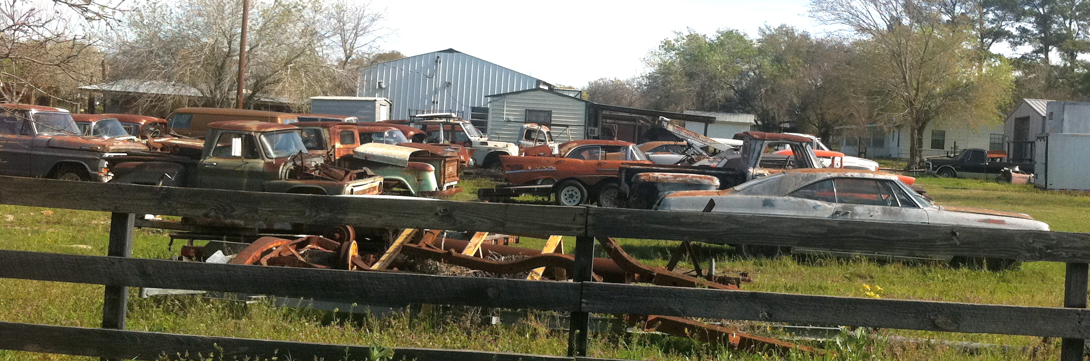 Collection of Cars Behind Fence in Bastrop County